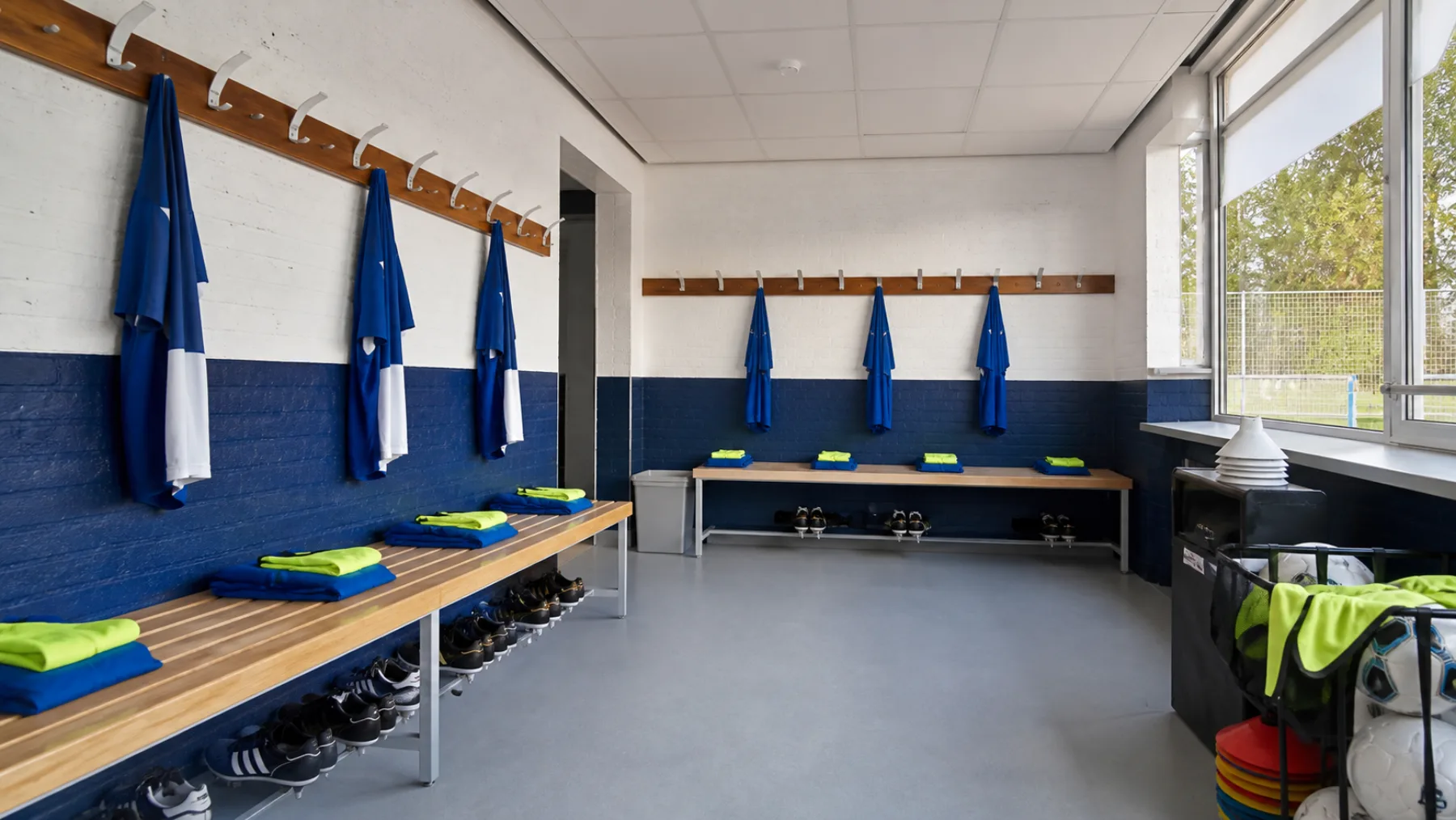 Praktische blauw-witte kleedkamer met trainingsmateriaal